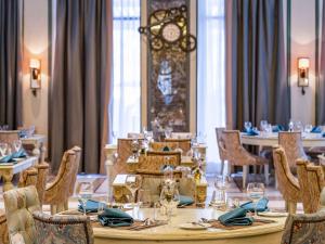 a dining room with a table and chairs and a clock at Rixos Premium Seagate in Sharm El Sheikh