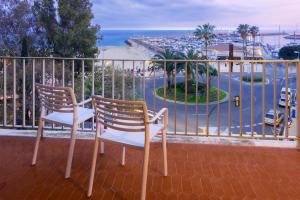 2 sillas sentadas en un balcón con vistas a la playa en Mònica Mar Apartments, en Cambrils