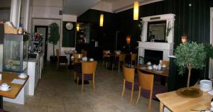 a restaurant with tables and chairs and a clock at The Old Bank Bruff Townhouse in Bruff