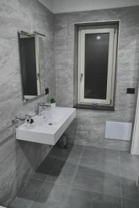 a bathroom with a white sink and a mirror at Affittacamere ONE in Frascineto
