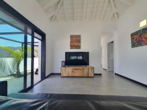 a living room with a tv and a large window at Casa Fielato in Los Barros