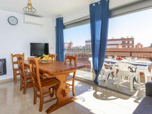 a dining room with a table and a large window at Apartment Vaixell by Interhome in Miami Platja +13 photos