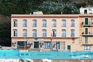 un hôtel avec une piscine en face d'un bâtiment dans l'établissement Hotel l'Approdo, à Porto Azzurro