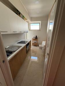 a small kitchen with white cabinets and a window at Casa di Nonna in Manfredonia