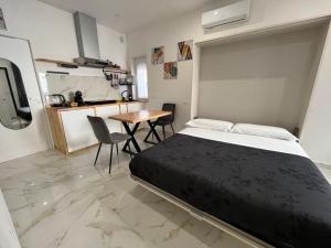 a bedroom with a bed and a table and a kitchen at RoomSovama in Pescara