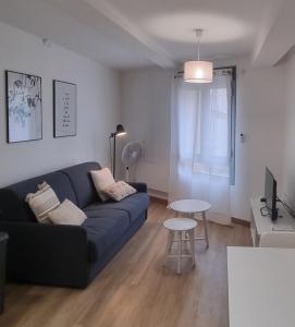 Una sala de estar con un sofá azul y una mesa. en Moderne & Lumineux - Hyper Centre, en Tournon-sur-Rhône