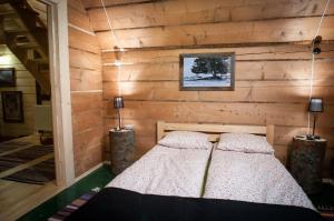 1 dormitorio con 1 cama en una pared de madera en Legenda Tatr, en Zakopane