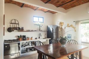 a kitchen with a wooden table and a refrigerator at Casa Botanica in Lo de Marcos