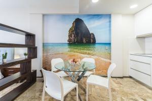 ein Esszimmer mit Tisch und Blick auf das Meer in der Unterkunft Golden Beach Luxury Las Canteras in Las Palmas de Gran Canaria