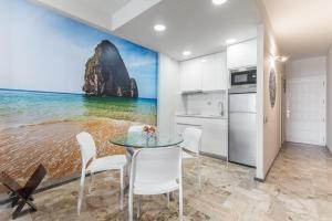 eine Küche mit einem Tisch, Stühlen und einem Berg in der Unterkunft Golden Beach Luxury Las Canteras in Las Palmas de Gran Canaria