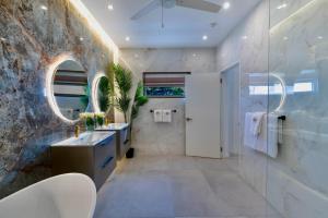 a bathroom with a sink and a white refrigerator at Solaris Beach House - Beachfront Property, St James in Saint James +32 photos