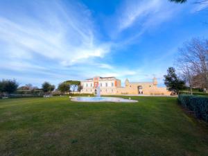 a large building with a fountain in the middle of a field at Relais Il Santissimo in Turi +94 photos