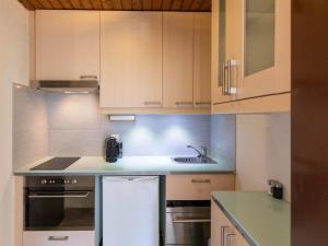 een keuken met witte kasten en een spoelbak bij Apartment Gamat 49 by Interhome in Villars-sur-Ollon