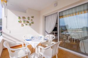 a dining room with a table and chairs and a balcony at Sol in Port d'Alcudia