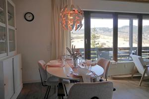 a dining room with a table with chairs and a chandelier at Ferienwohnung Schöner Ausblick in Willingen