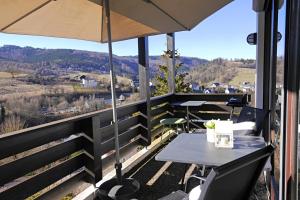 a patio with a table and an umbrella at Ferienwohnung Schöner Ausblick in Willingen +27 photos