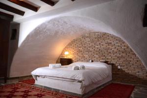 a bed in a room with a brick wall at Villa Katerinas in Magoúliana