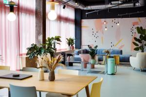 a dining room with tables and chairs and plants at MIAMI House in Hamburg