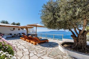 um pátio com cadeiras e uma árvore e água em Archodiko at Palio Klima em Neo Klima