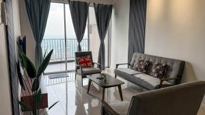 Taiping Chill Retreat Homestay near Lake Garden في تايبينغ: غرفة معيشة مع أريكة وطاولة ونافذة كبيرة