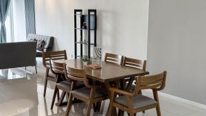 Taiping Chill Retreat Homestay near Lake Garden في تايبينغ: غرفة طعام مع طاولة وكراسي خشبية