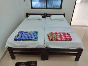 a bed with two bags sitting on top of it at ANAND BHAWAN i in Shivāpur +10 photos
