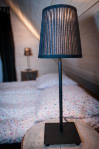 a lamp sitting on a table next to a bed at Legenda Tatr in Zakopane