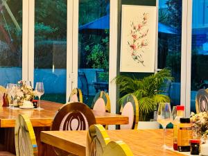 a restaurant with wooden tables and chairs with wine glasses at Ndaba Golf Lodge & Hello Beautiful Day Spa in Queenstown