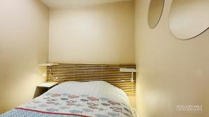 a small bedroom with a bed with a blanket on it at Appartement Sunrise au pied de la plage in Merlimont