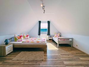 a attic bedroom with two beds and a window at Ferienwohnung 3 & 4 Wald & See in Zirchow