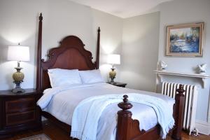 a bedroom with a large wooden bed with two lamps at Historic Manor Overlooking Park in Bloomington