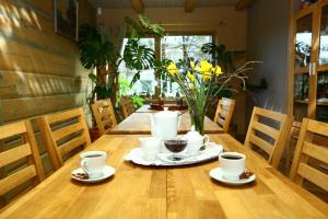 una mesa de madera con tazas y platillos. en Arciau Juros, en Palanga