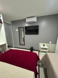 a bedroom with two beds with a red blanket at Praia do Carneiros Flat Hotel, AP 303 Ap comandado por alexa in Tamandaré +18 photos