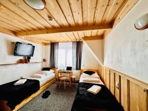 una camera d'albergo con due letti e una scrivania di Willa u podnóża Tatr Cztery Pory Roku a Kościelisko