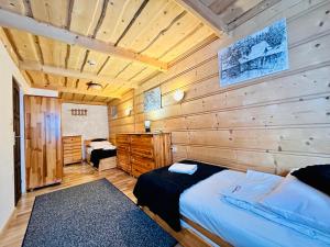 una camera da letto con un letto e una parete di legno di Willa u podnóża Tatr Cztery Pory Roku a Kościelisko