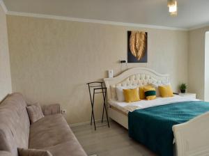 une chambre avec un lit et un canapé dans l'établissement Космос-Лайт, à Aqtöbe