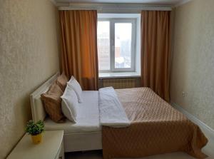 une petite chambre avec un lit et une fenêtre dans l'établissement Космос-Лайт, à Aqtöbe 19 autres photos