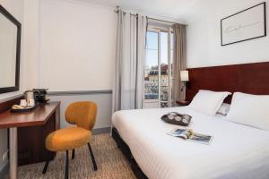 a hotel room with a bed and a desk and a chair at Best Western Hotel Lakmi Nice in Nice