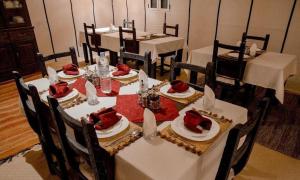 uma sala de jantar com mesas brancas e cadeiras com comida em Merzouga Luxury Glamping em Merzouga