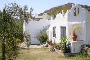 ein weißes Haus mit Pflanzen davor in der Unterkunft Soles Blancos Serranita in Alta Gracia