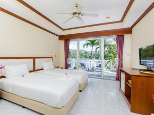 卡图Serenity Lakeside Resort的一间带两张床、一台电视和一个阳台的卧室