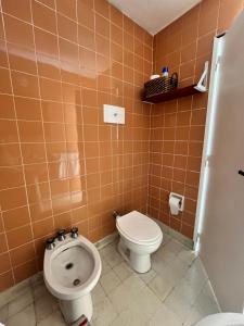 a bathroom with a toilet and a bidet at Casa en alquiler temporario in Ramallo +4 photos