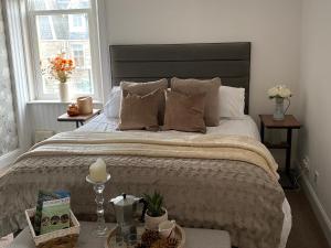 a bedroom with a large bed and two windows at Alba Apartment Central Pitlochry in Pitlochry