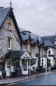 a stone building with a shop in front of it at Alba Apartment Central Pitlochry in Pitlochry