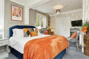 a bedroom with a bed with an orange blanket at Foxhills of Shanklin in Shanklin