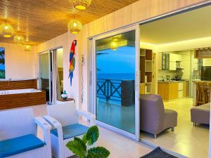 a living room with a sliding glass door to the ocean at Hermosa Suite frente al mar en Tolu-Sucre in San Silvestre +133 photos