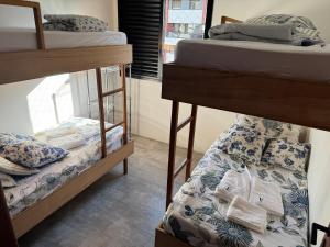 a room with two bunk beds and a window at Riviera 200m Praia Serv de Praia and Pisc Aquec in Bertioga +71 photos