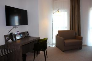 a room with a desk and a chair and a television at Mercure Saint Malo Balmoral in Saint Malo