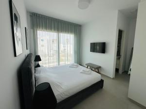 ein Schlafzimmer mit einem Bett und einem großen Fenster in der Unterkunft Luxury 4 bdr Villa Nerida in Klorakas