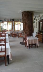 a restaurant with tables and a tree in the middle at Hotel la Masia in Portbou